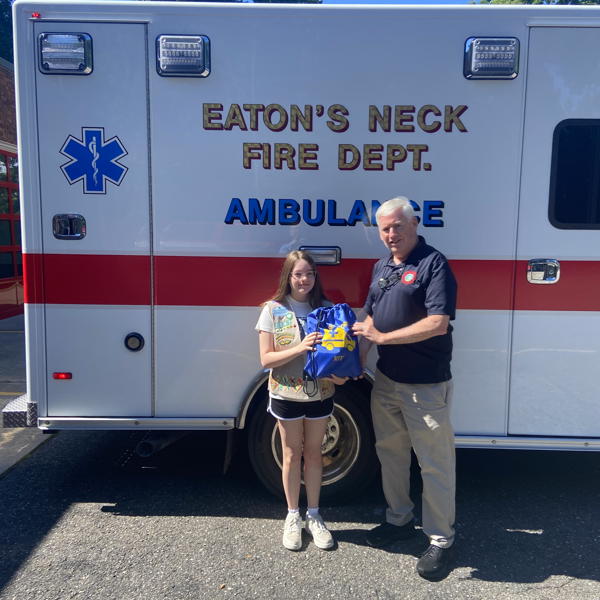Olivia LoBue presented two sensory kits to Eaton’s Neck Fire Department Captain Andy Reid, to be used on local ambulances to calm residents during stressful emergency situations. 