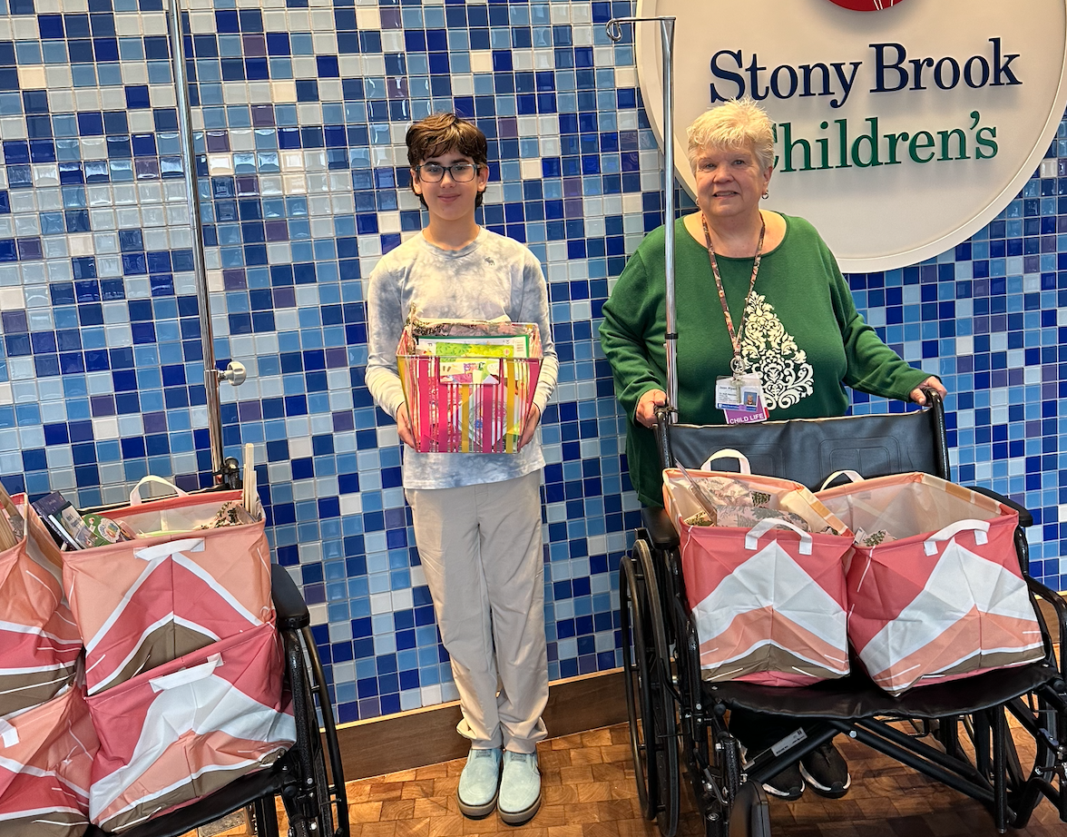 Goldstein and Joan Alpers, the Director of Child Life Services at Stony Brook University Hospital, with the bags of art supplies he collected for patients.