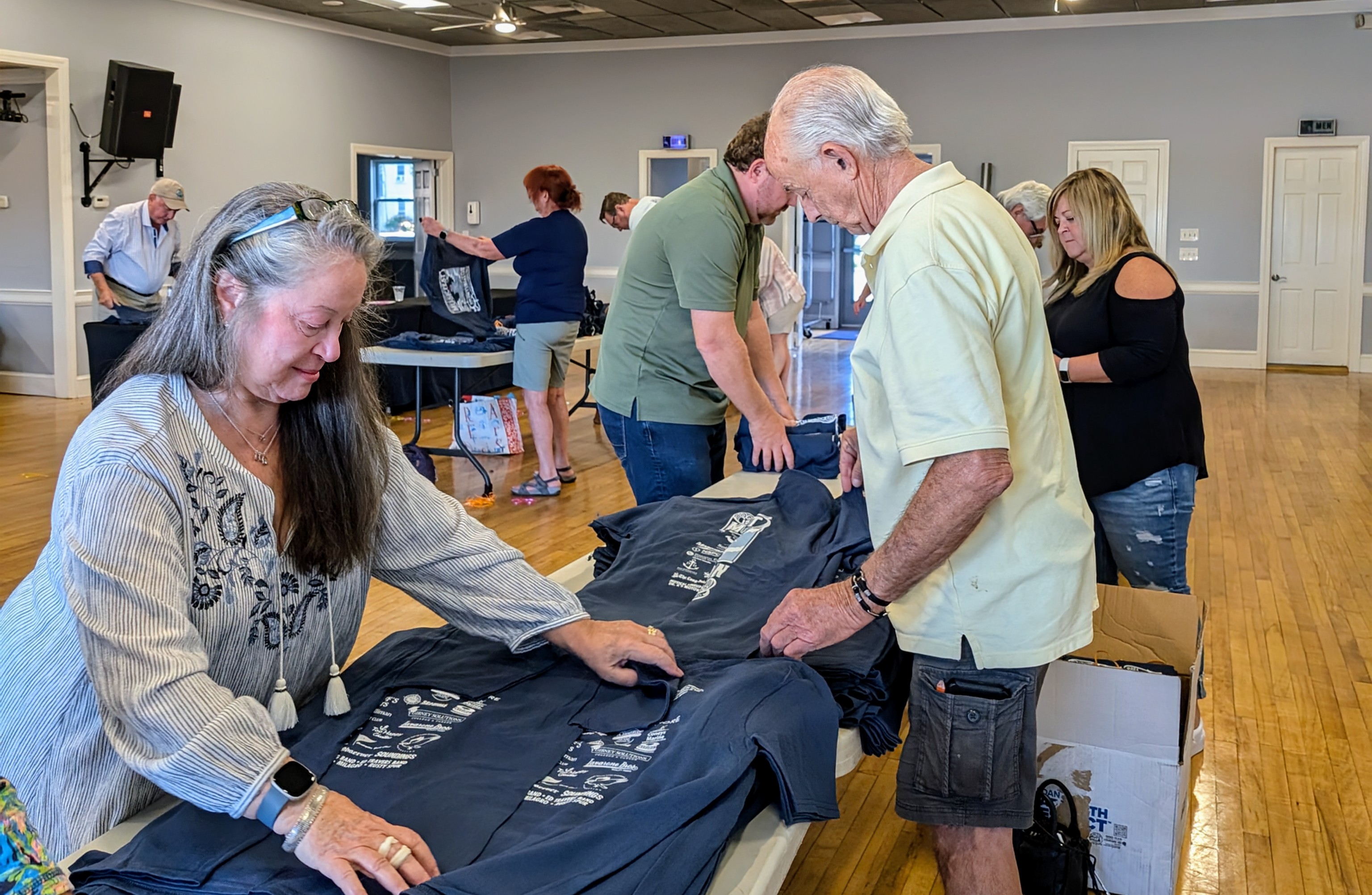 Huntington Lighthouse Preservation Society (HLPS) volunteers prepare t-shirts for the 15th annual Huntington Lighthouse Musicfest to be held on Saturday, August 31 (rain date Sunday, September 1).