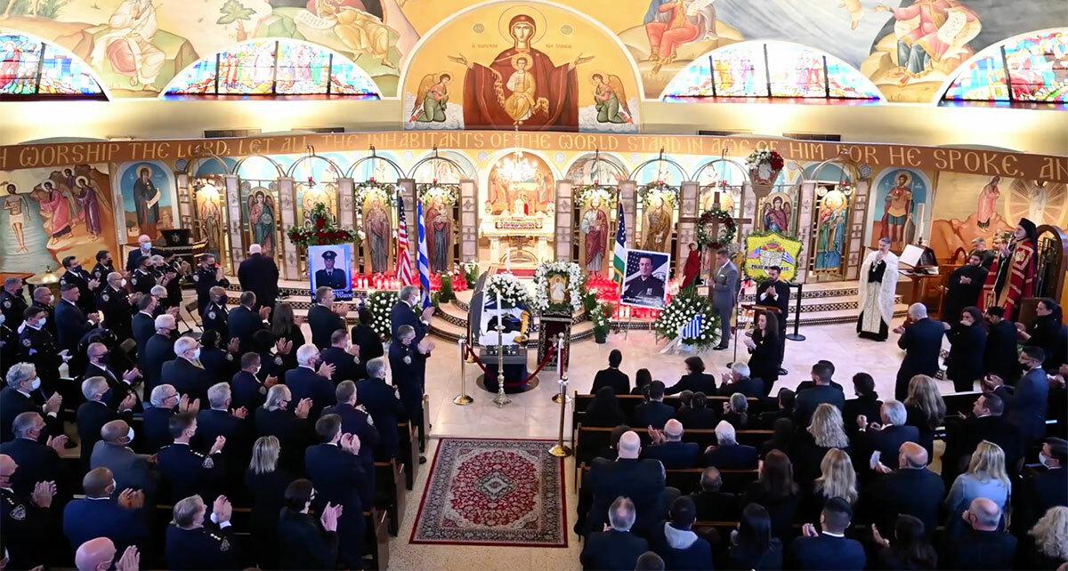 Family, friends and law enforcement members at St. Paraskevi Greek Orthodox Church in Greenlawn applaud the wife of NYPD officer Anastasios Tsakos, who was killed in the line of duty on April 27. Irene Tsakos was the last to speak at a funeral service today, honoring her husband.