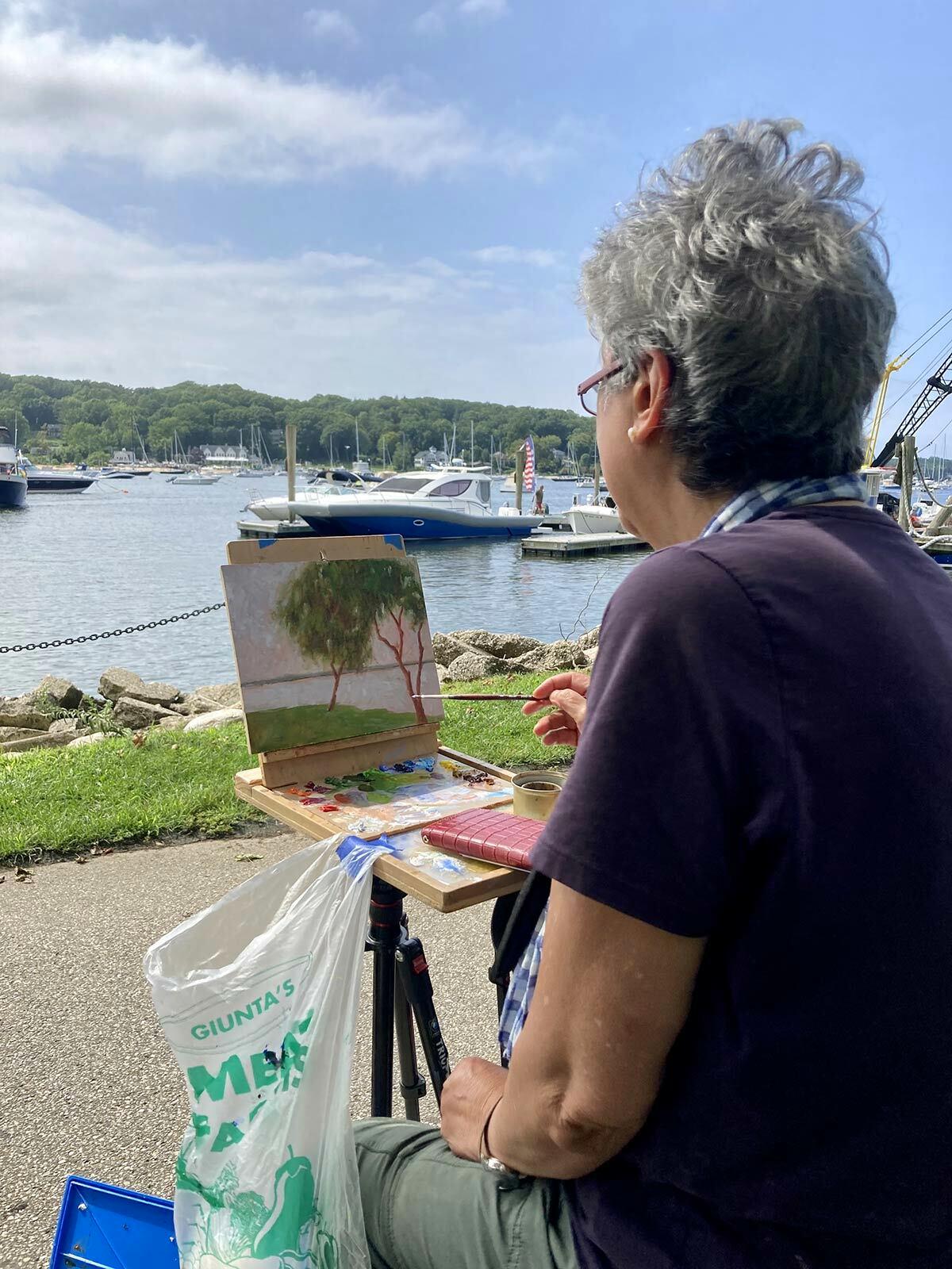 Cecile Bax works on a painting of Northport Harbor.