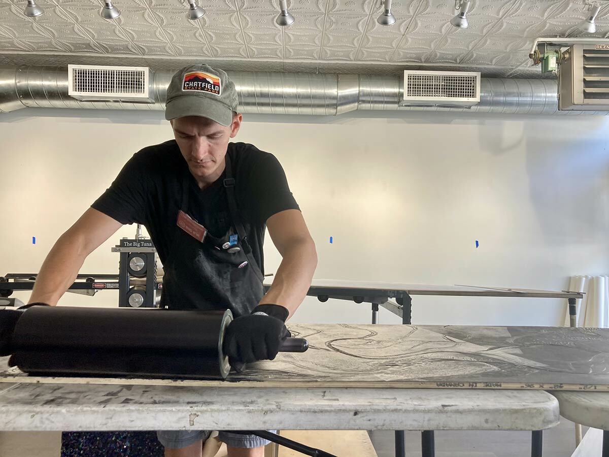 BIG INK founder Lyell Castonguay coats a woodblock with ink at yesterday’s portion of the weekend event.