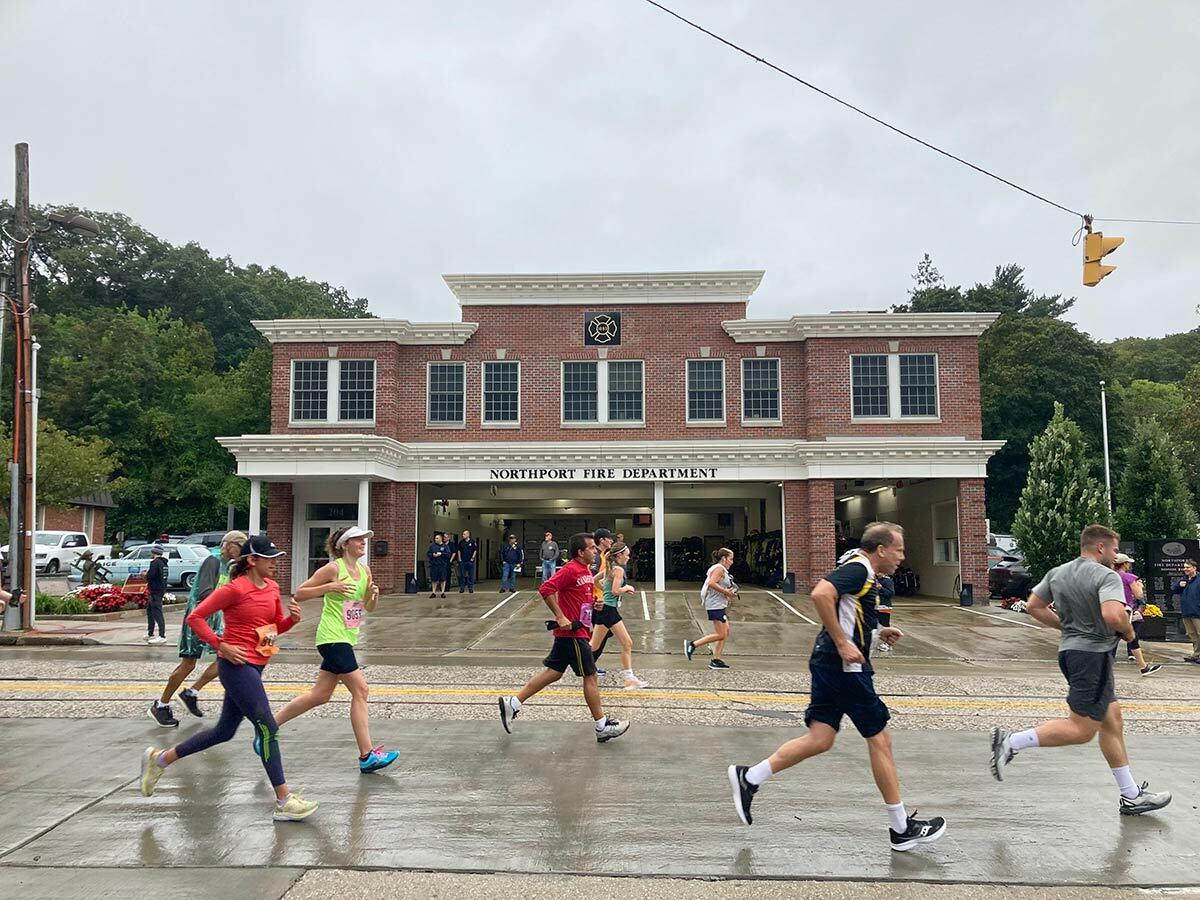 Runners in the Great Cow Harbor 10K pass the Northport Fire Department.