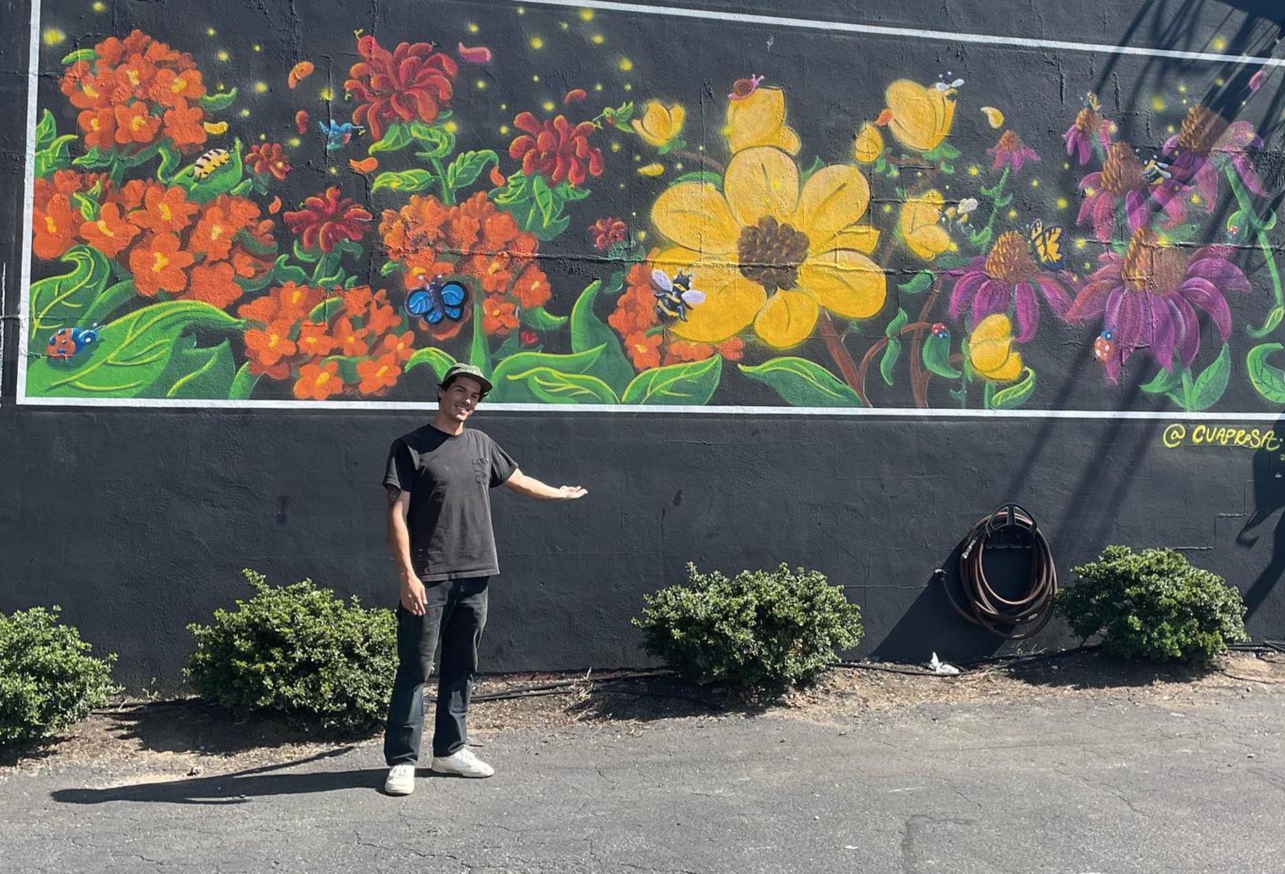 2020 Northport High School graduate and current FIT student Anthony Cuadros in front of the mural he completed at Batata Cafe and Grille in Northport.