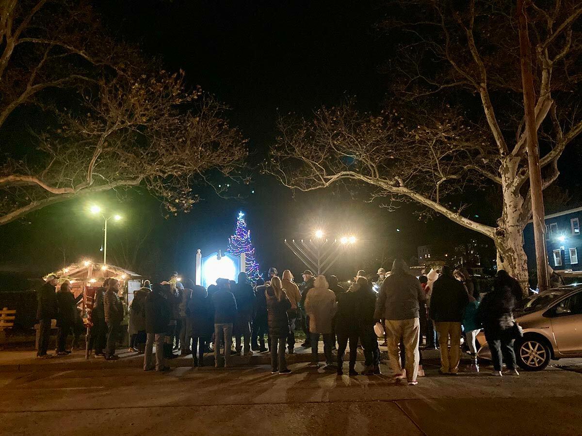 A crowd gathered to celebrate the Jewish Festival of the Lights with East Northport Jewish Center Rabbi Ian Silverman yesterday evening in Northport Village.