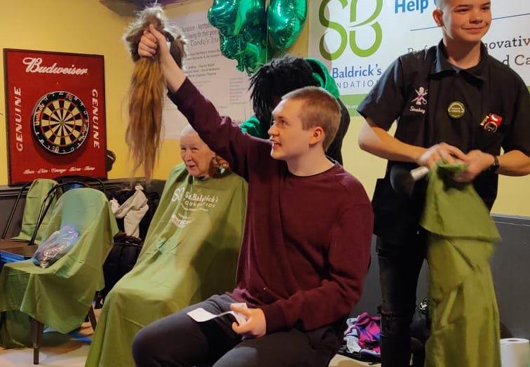 Kenneth Reidenbach alongside his grandmother Betty at the March 2023 St. Baldrick&#39;s event. Betty will brave the shave again this year – her 21st time – in honor of Kenneth, who passed away from cancer in December. Photo via Facebook. 