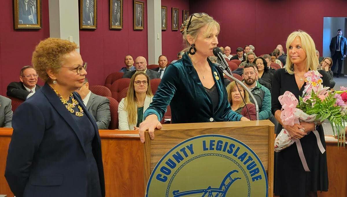 Pictured: Legislator Stephanie Bontempi (center at podium) with County-Wide Woman of Distinction, Sharon Richmond (right) and Grace Ioannidis (left), Director of the Suffolk County Department of Women’s Services.