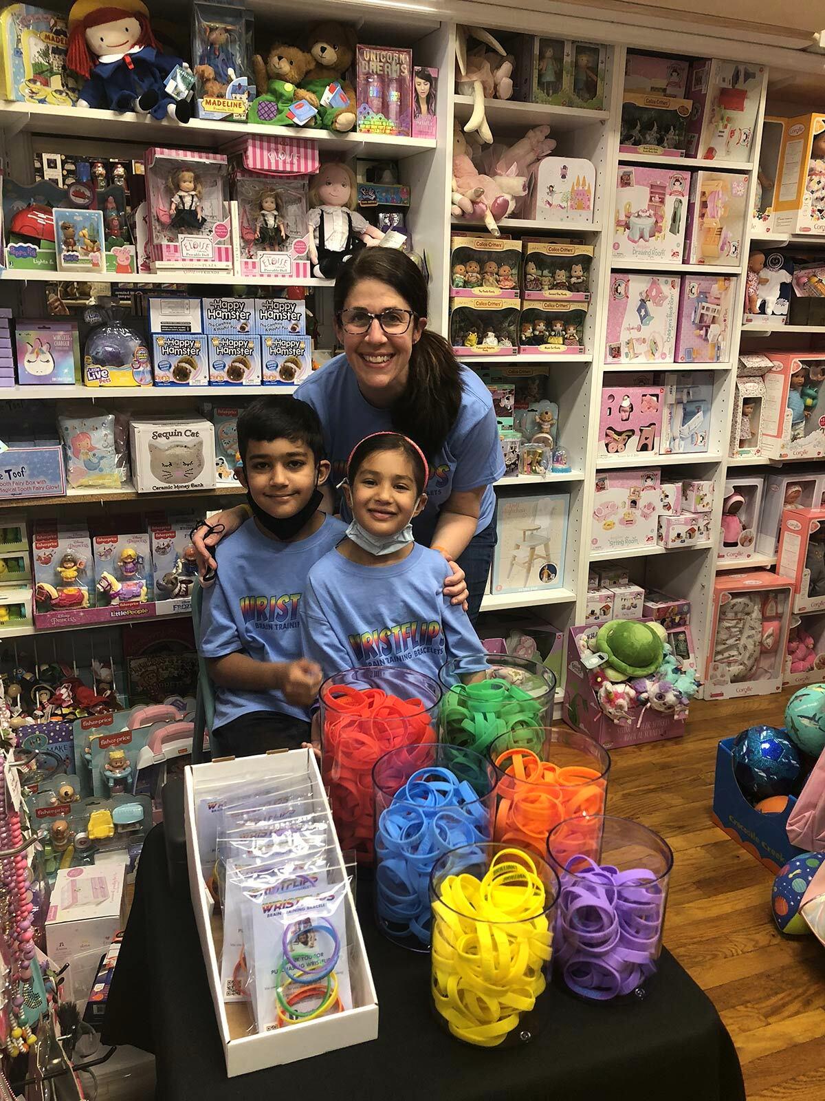 Northport resident Leigh Boodoo and her children at a Wristflips pop-up event at Einstein’s Attic on Main Street last weekend.