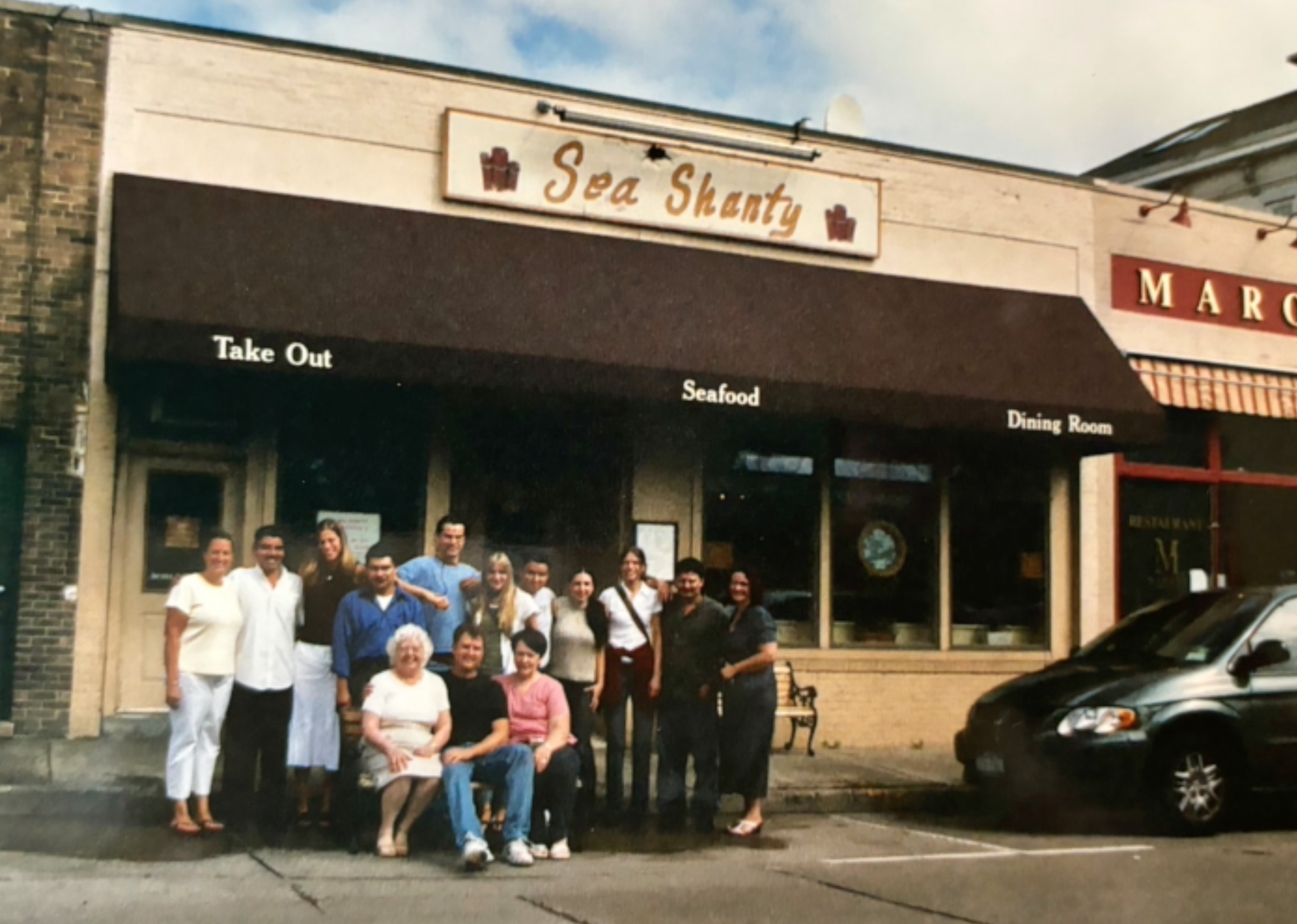 Restaurant owner Marie José Blazej (seated, left) and staff in front of the Sea Shanty on Woodbine Avenue in Northport Village. Blazej passed away last month, on March 21. Photo via the Gately Funeral Home website.