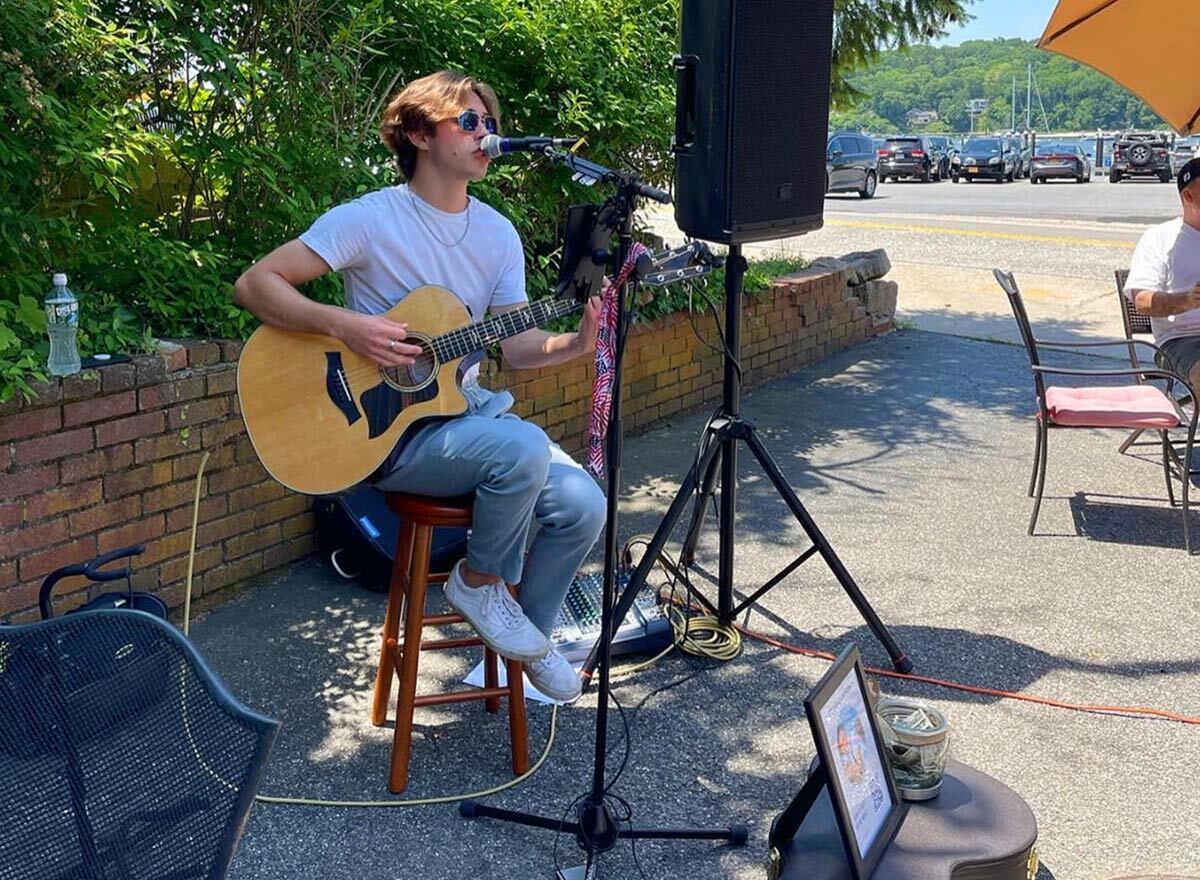 A musician plays live outside Copenhagen Bakery in this undated photo. The bakery has since been issued a code violation for the music, and all entertainment has been halted. Photograph via Instagram.
