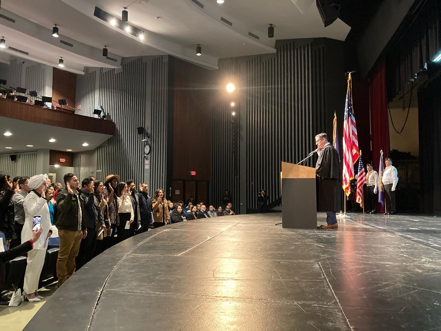 Judge James M. Wicks, United States Magistrate Judge for the Eastern District of New York, administers the Oath of Allegiance to 75 citizenship candidates at a naturalization ceremony at Northport High School this past Friday, February 14. 