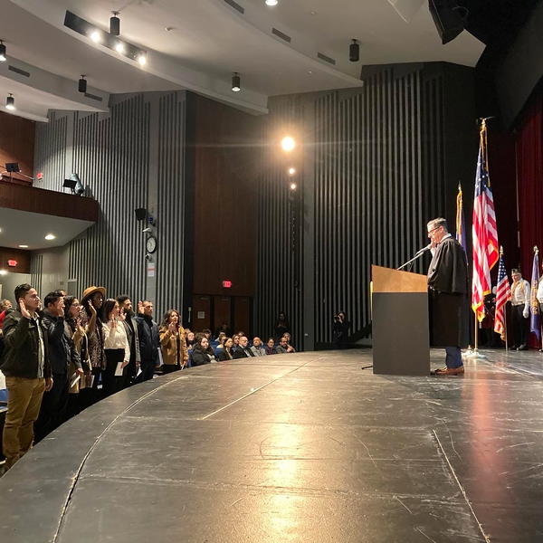 Judge James M. Wicks, United States Magistrate Judge for the Eastern District of New York, administers the Oath of Allegiance to 75 citizenship candidates at a naturalization ceremony at Northport High School this past Friday, February 14. 