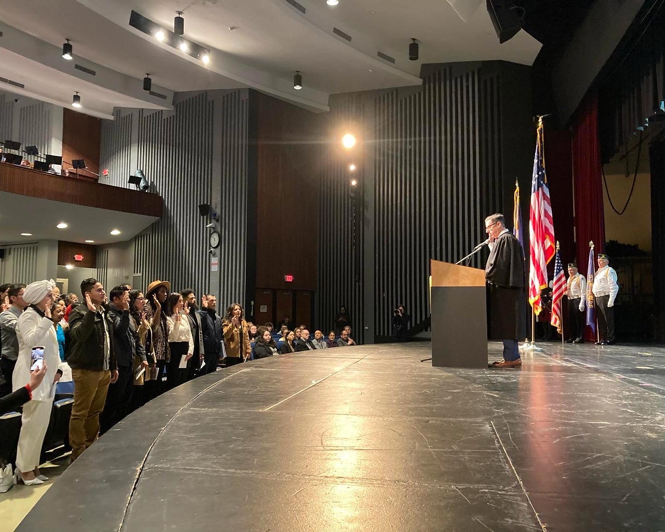 Judge James M. Wicks, United States Magistrate Judge for the Eastern District of New York, administers the Oath of Allegiance to 75 citizenship candidates at a naturalization ceremony at Northport High School this past Friday, February 14. 