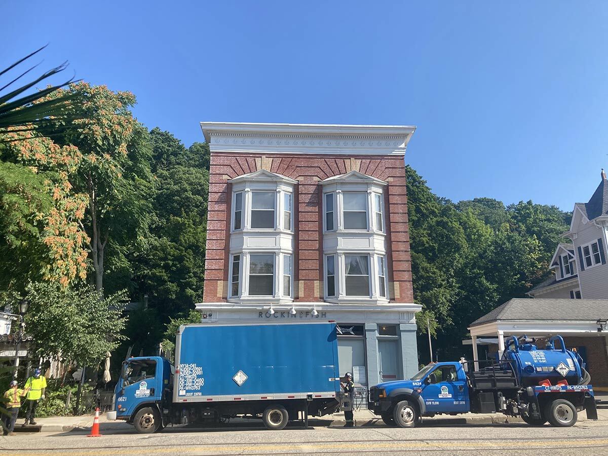 Miller Environmental, pictured here assessing impacted storm drains on Main Street and removing any material that is remaining in the drains to prevent ongoing releases to Northport Harbor, was hired to conduct cleanup activities after rain caused leaked dielectric fluid to flow down Main Street.