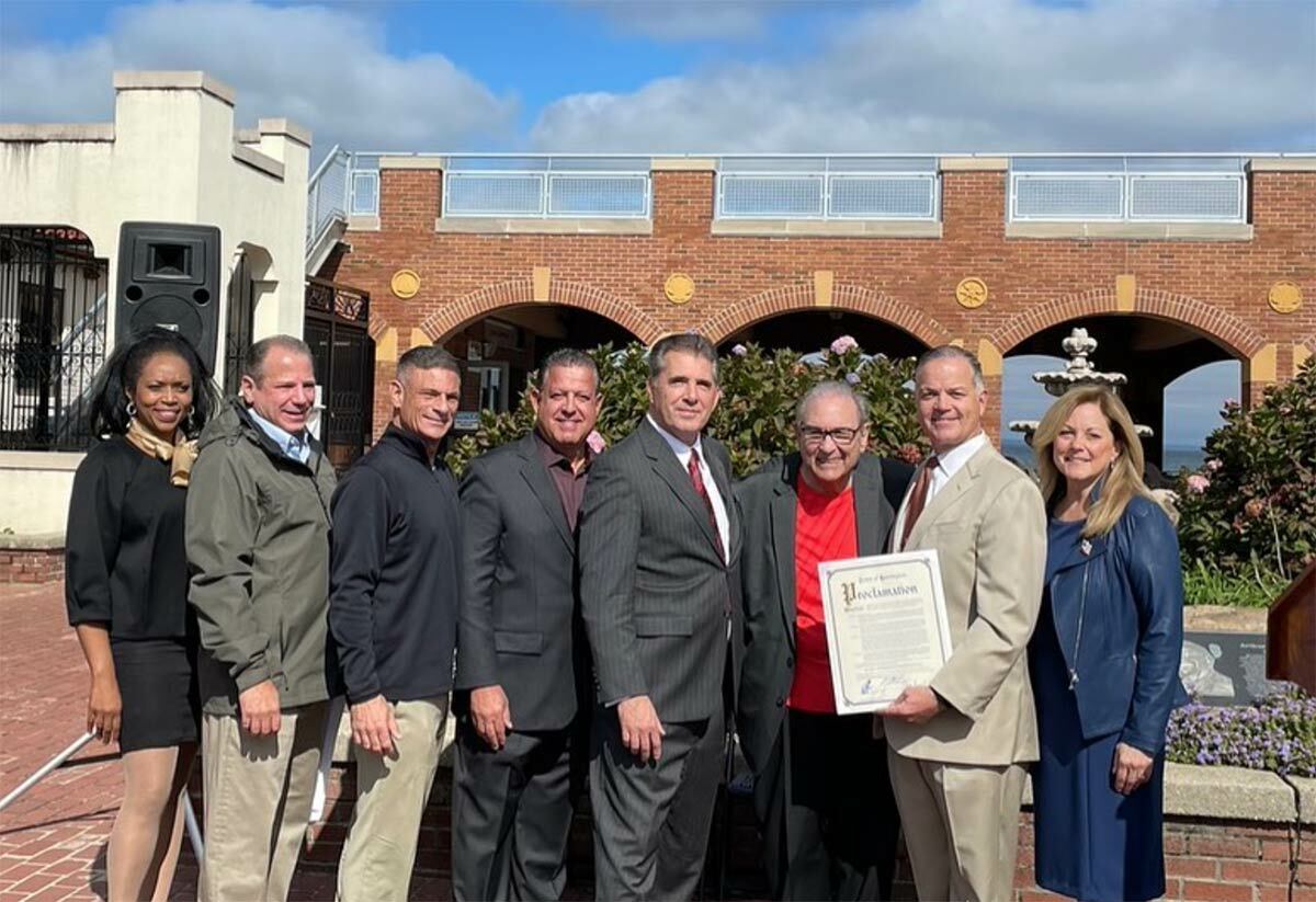 Officials from the town of Huntington gather with former Town Supervisor Frank Petrone (in red) for the Crab Meadow Beach renaming ceremony on Friday, October 14. Photo via Facebook.