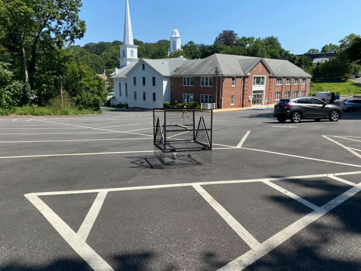 A compartment trap was set up in the rear parking lot of the First Presbyterian Church on Friday, August 6, to capture the hawk. Photo credit: Eileen Tucker D’Amore
