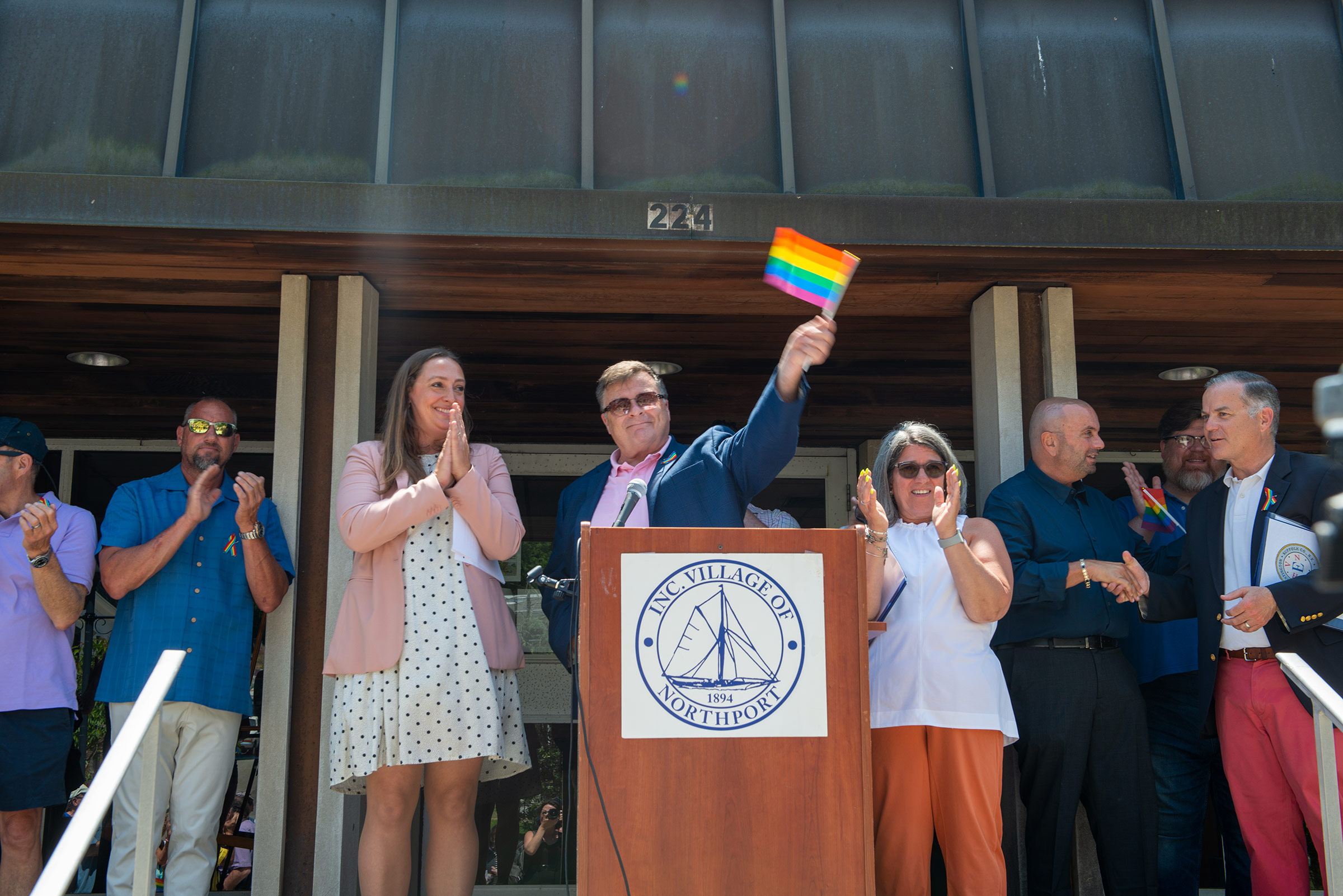 Northport Pridefest co-organizer Joe Schramm at the end of a flag-raising ceremony in Northport Village yesterday. Numerous local officials spoke at the event including co-organizer and Trustee Meghan Dolan (left) and Mayor Donna Koch (right). Northport Journal photo.