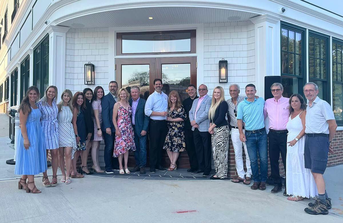 Friends and family of The Northport Hotel co-owners Kevin O’Neill and Richard Dolce after the ribbon-cutting ceremony on July 28.
