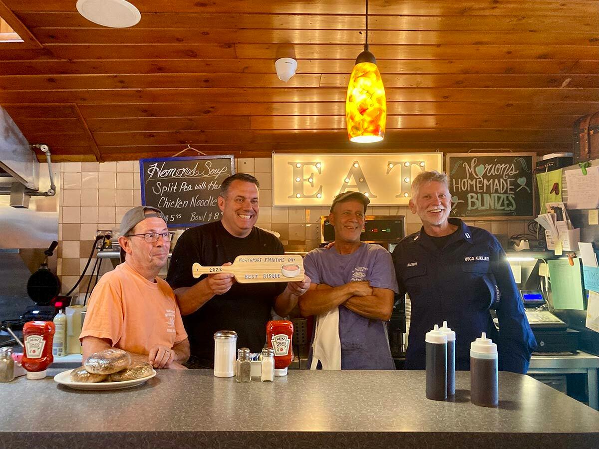 Bill Raisch (right) handed out awards to competition winners at the end of Maritime Day, including to, from left, Damon Pratt, Denis Beyersdorf and Tim Hess of the Northport Shipwreck Diner, winner of best bisque. Skippers won for best chowder. Northport Journal photo.