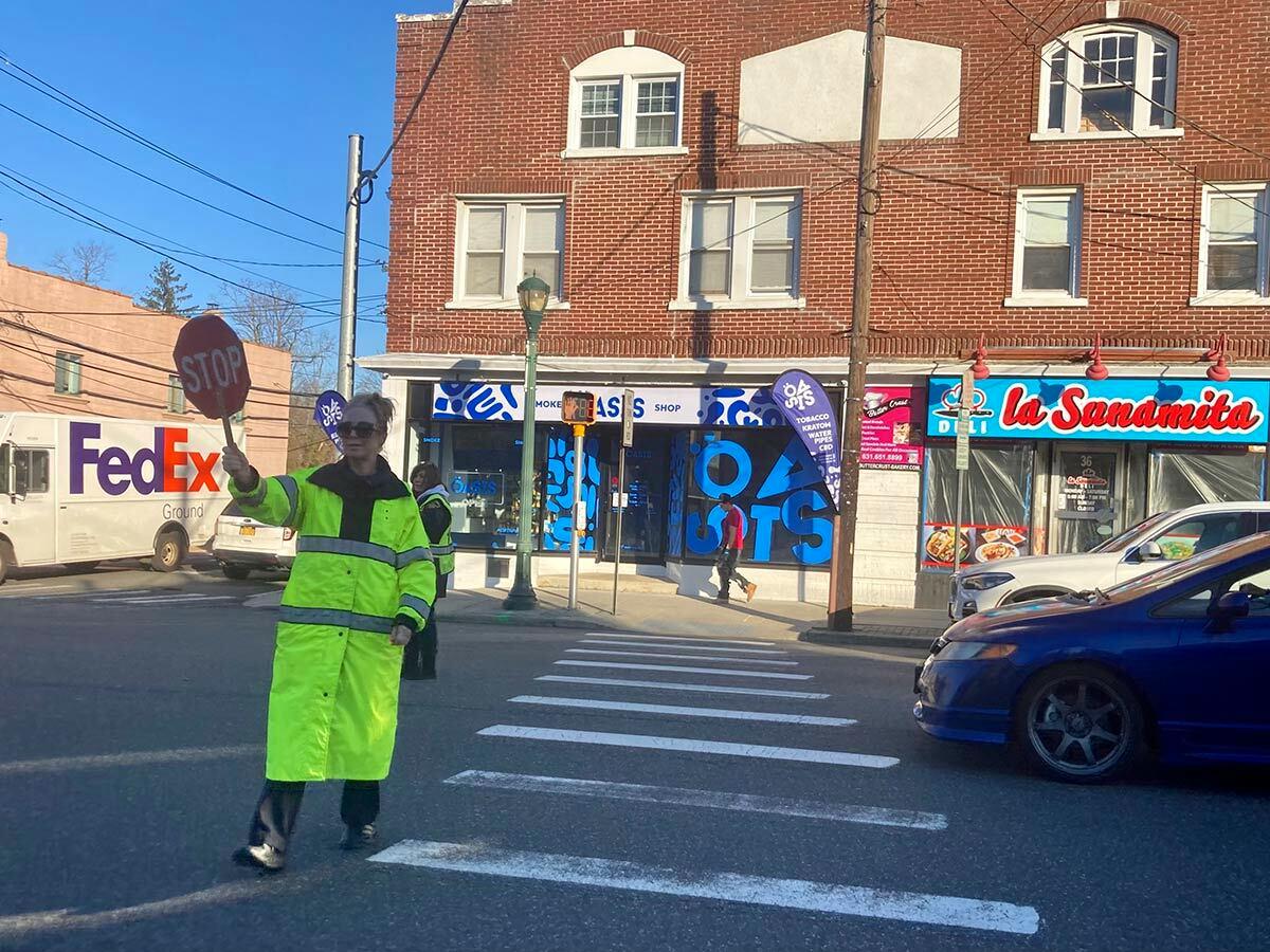 A crossing guard halts traffic in front of Oasis Smoke Shop, one of five smoke shops within 0.7 miles of Larkfield Road.