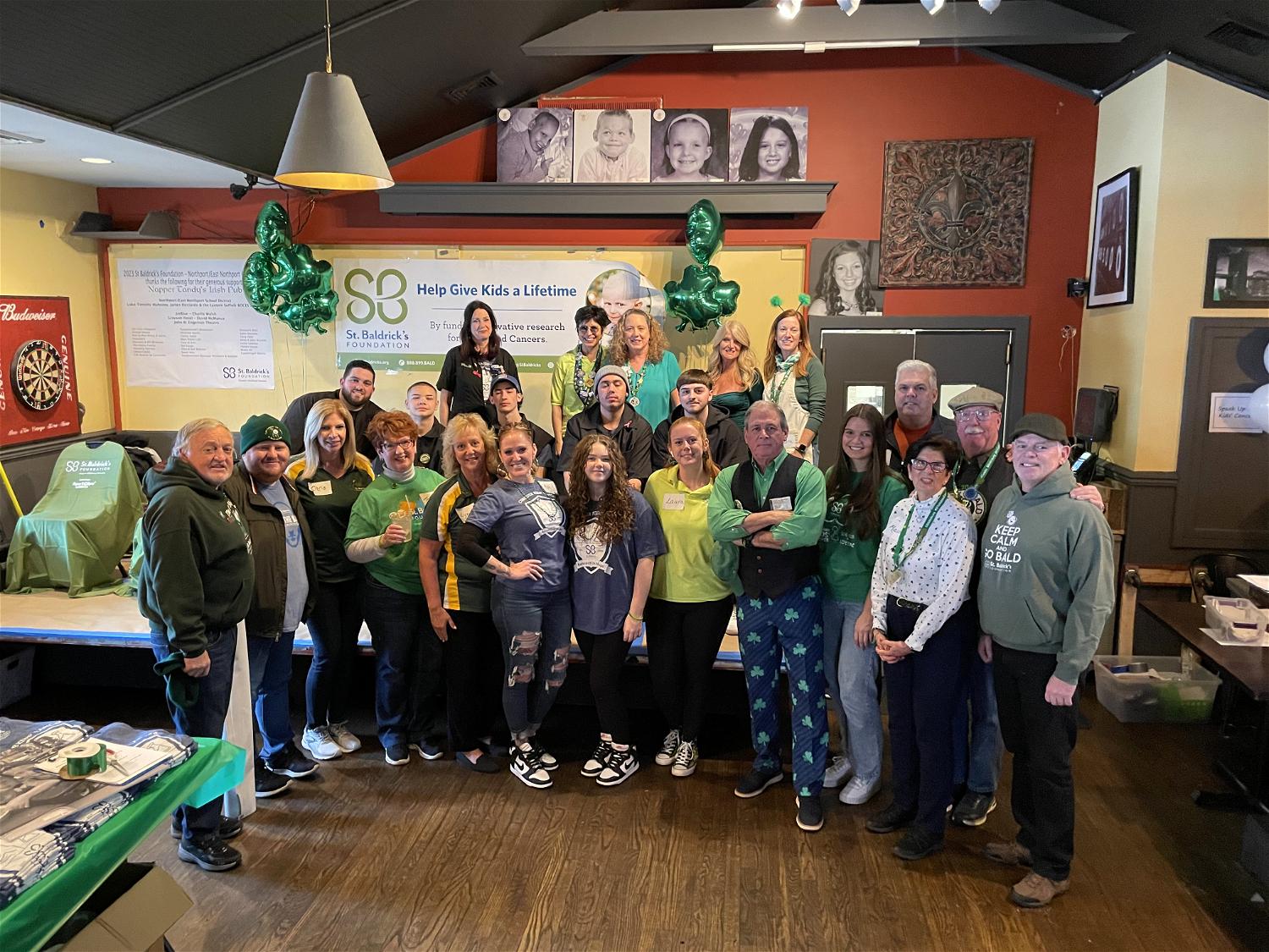 Nora Nolan (top right) with the March 2023 Northport St. Baldrick&#39;s committee and barber volunteers at the Napper Tandy&#39;s event. 