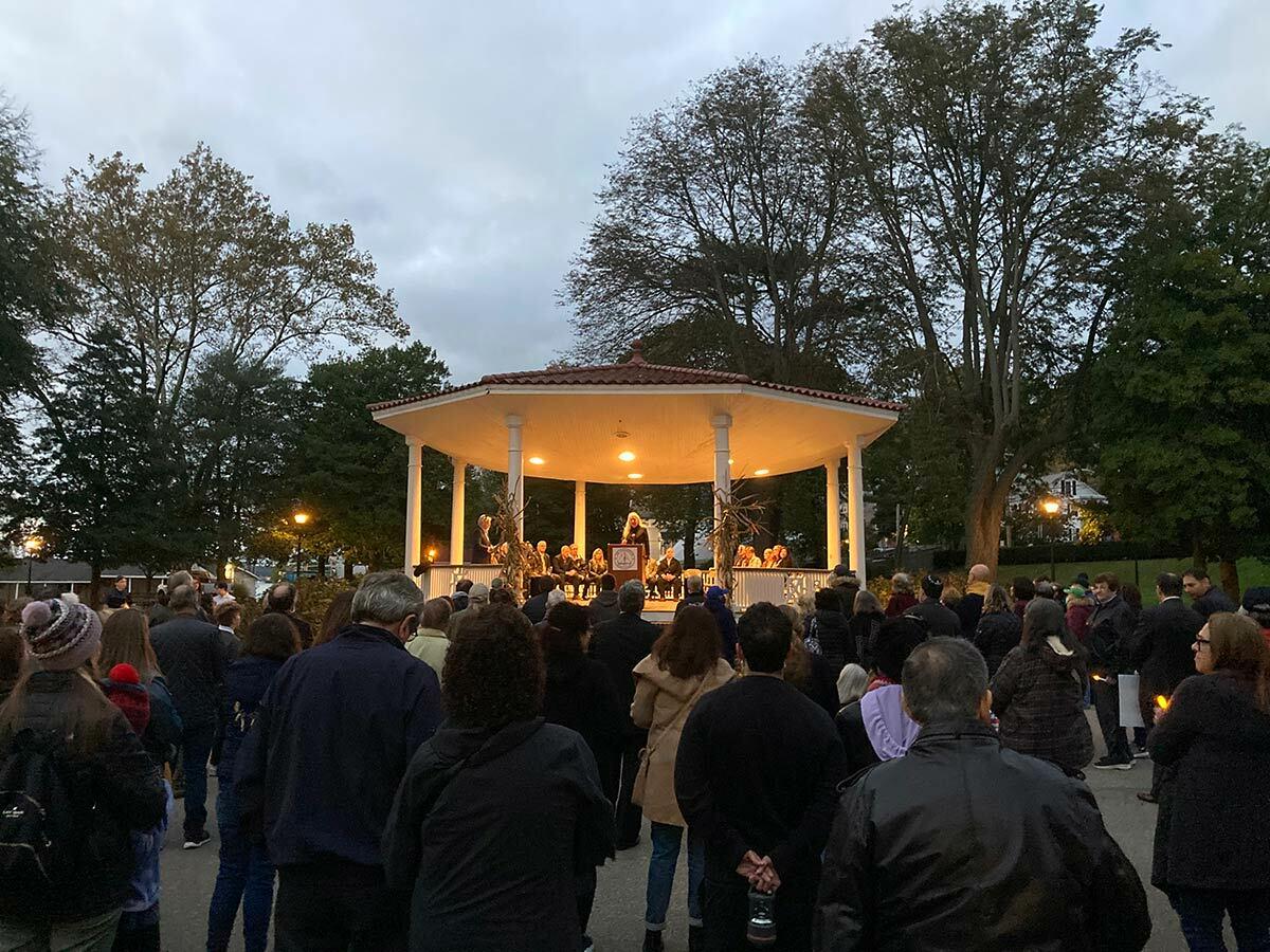 A crowd listens to Pastor Rachel Vione of the First Presbyterian Church of Northport at the Northport Village Candlelight Vigil Against Hate.