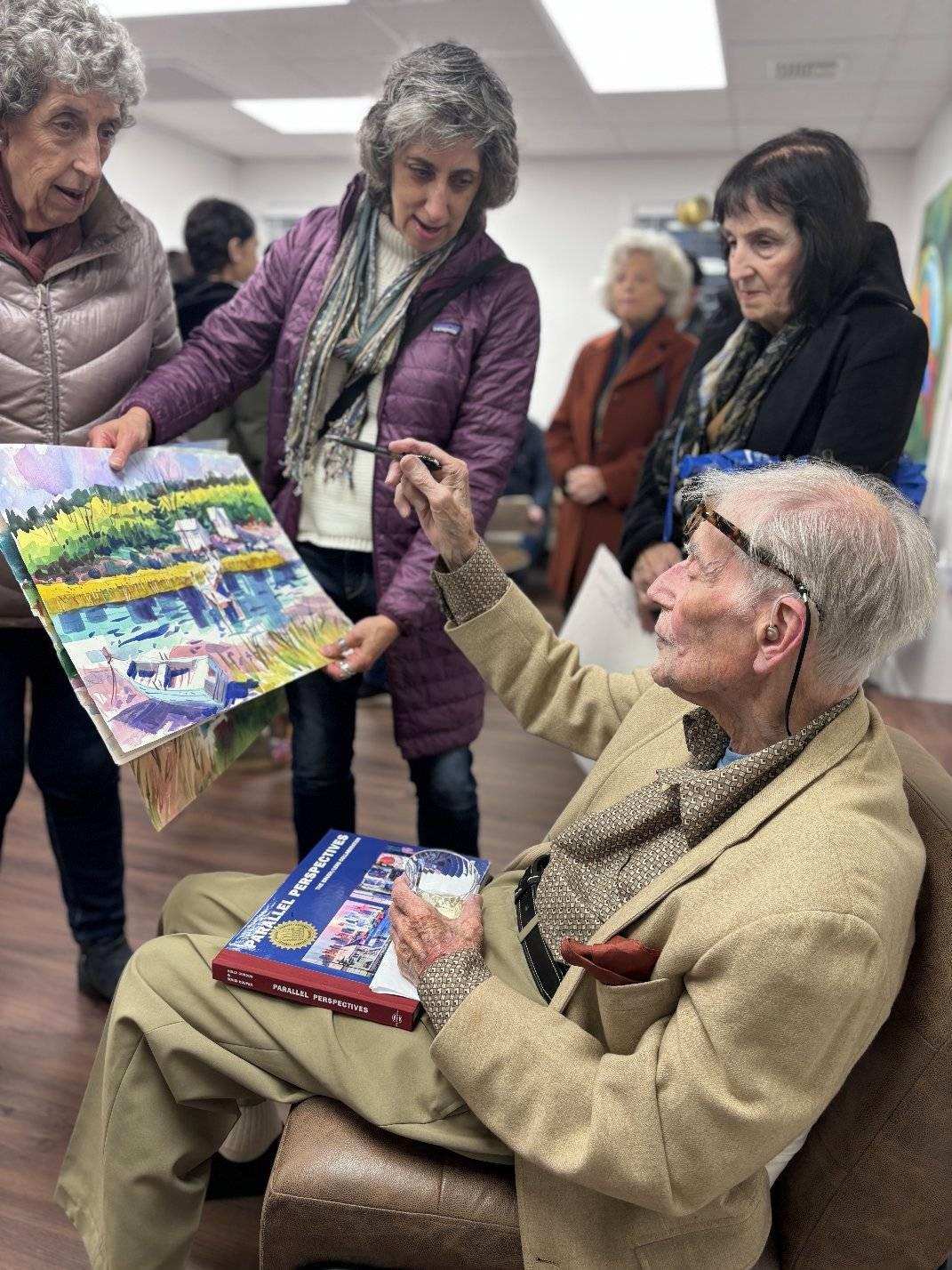 Ward Hooper discusses his artwork with his fans at the April 12-13 exhibit and sale at RB Homes Realty. Photo courtesy Arbi Asadourian. 